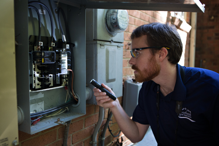 Home Inspector and ScribeWare Report Inspection Software advisor Tim Trickle using a flashlight to inspect an electrical panel